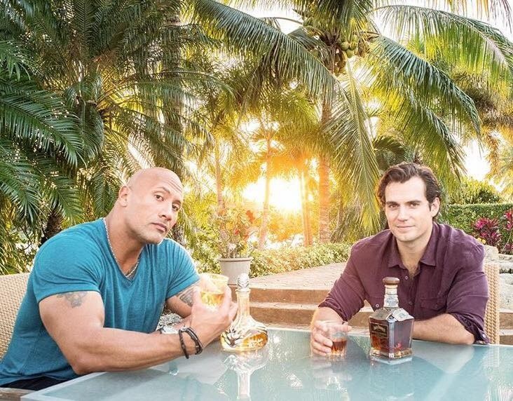 Dwayne johnson and henry cavill share a drink; might they be sharing a screen together soon? Source: dwayne the rock johnson via facebook.